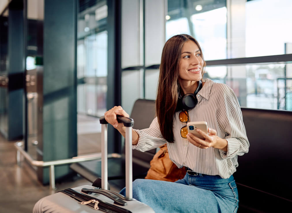 Girl at the airport booking on the mobile - Air Dolomiti
